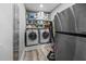 Functional laundry room with side-by-side washer and dryer, shelving, and storage at 711 Hinsdale St, Raleigh, NC 27605