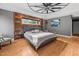 Chic main bedroom with wood accent wall, tray ceiling with fan and hardwood floors at 711 Hinsdale St, Raleigh, NC 27605