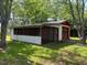 Detached garage features a screened in area, surrounded by lush greenery at 727 Queens Ave, Dunn, NC 28334