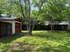 Garage sits at the back of a lush yard with mature trees and fencing at 727 Queens Ave, Dunn, NC 28334