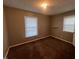 A sunny bedroom with neutral walls, plush carpeting, and two windows at 727 Queens Ave, Dunn, NC 28334