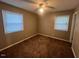 A sunny bedroom with two windows, overhead fan and neutral decor at 727 Queens Ave, Dunn, NC 28334