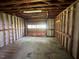 Interior of the garage with exposed framing and roll-up door at 727 Queens Ave, Dunn, NC 28334