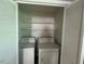 A functional laundry area has a washer, dryer, and built-in shelving at 727 Queens Ave, Dunn, NC 28334