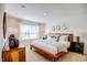 Serene main bedroom featuring a wooden bed frame, neutral bedding, and natural light from a large window at 7461 Michelle Rd, Rocky Mount, NC 27803