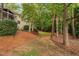 A treelined backyard creating a serene and private outdoor space with a gentle slope and natural landscaping at 7808 Umstead Forest Dr, Raleigh, NC 27612