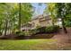 Lush backyard featuring a screened porch, stone fireplace, and retaining wall, perfect for outdoor enjoyment at 7808 Umstead Forest Dr, Raleigh, NC 27612