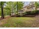 Spacious backyard with a screened-in porch, brick retaining wall, stone fireplace, and lush trees at 7808 Umstead Forest Dr, Raleigh, NC 27612