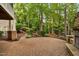 Charming backyard with a stone fireplace, patio, and lush landscaping, creating a serene outdoor retreat at 7808 Umstead Forest Dr, Raleigh, NC 27612