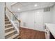 Finished basement features carpeted stairs and hardwood floors, white walls and trim, and a wet bar area at 7808 Umstead Forest Dr, Raleigh, NC 27612