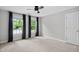 Bedroom with a ceiling fan and three windows offers plenty of sunlight into the room and shows off the neutral walls and carpet at 7808 Umstead Forest Dr, Raleigh, NC 27612