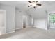 Spacious bedroom features a vaulted ceiling with fan, neutral walls and carpet, closet, and window with a view at 7808 Umstead Forest Dr, Raleigh, NC 27612