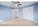 Bedroom with a ceiling fan, carpet floors, an adjacent stairway, and double doors at 7808 Umstead Forest Dr, Raleigh, NC 27612