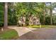 Beautiful two-story home with brick and siding exterior, circular driveway and mature trees for added curb appeal at 7808 Umstead Forest Dr, Raleigh, NC 27612