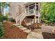 Brick home with stairs leading to a screened-in porch, complemented by lush landscaping at 7808 Umstead Forest Dr, Raleigh, NC 27612