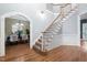 Bright foyer showcasing hardwood floors and a staircase, with an arched entryway to the dining room at 7808 Umstead Forest Dr, Raleigh, NC 27612