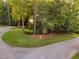Landscaped front yard with mature trees and winding driveway at 7808 Umstead Forest Dr, Raleigh, NC 27612