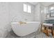 Close up on a soaking tub with a white marble backsplash in the shower at 8517 Evans Mill Pl, Raleigh, NC 27613