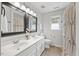 Bathroom with double sink vanity, shower with curtain, and a window for natural light at 8517 Evans Mill Pl, Raleigh, NC 27613