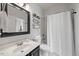 Clean bathroom featuring a vanity with black hardware, a shower-tub combo, and a white shower curtain at 8517 Evans Mill Pl, Raleigh, NC 27613