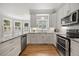 Bright kitchen features stainless steel appliances, granite counters, hardwood floors, and a bay window at 8517 Evans Mill Pl, Raleigh, NC 27613