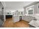 Open kitchen has stainless appliances, granite counters, white cabinetry, and hardwood floors at 8517 Evans Mill Pl, Raleigh, NC 27613