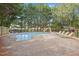 Backyard pool with lounge chairs, playground, and surrounded by trees at 8517 Evans Mill Pl, Raleigh, NC 27613