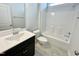 Clean bathroom with white tiling, featuring a vanity with dark cabinets and a shower-tub combination at 8813 Moss Glen Dr, Raleigh, NC 27617