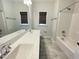 Bathroom featuring a double sink vanity with modern fixtures, tile floor, and tub/shower combo at 8813 Moss Glen Dr, Raleigh, NC 27617