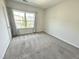 Cozy bedroom with neutral carpet and a large window with views of the neighborhood at 8813 Moss Glen Dr, Raleigh, NC 27617