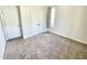 Bedroom with double doors, plush carpeting, and a single window, creating a simple and comfortable space at 8813 Moss Glen Dr, Raleigh, NC 27617