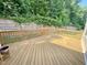 Spacious wooden deck surrounded by lush greenery and a retaining wall, ideal for entertaining at 8813 Moss Glen Dr, Raleigh, NC 27617