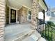 Inviting front porch with stone pillars and elegant black door, offering a charming entrance to the home at 8813 Moss Glen Dr, Raleigh, NC 27617
