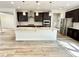 Modern kitchen boasts an island with granite countertop, stainless steel appliances, and dark wood cabinets at 8813 Moss Glen Dr, Raleigh, NC 27617
