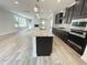 Kitchen featuring a large island with sink, stainless appliances, and views into the Gathering room at 8813 Moss Glen Dr, Raleigh, NC 27617