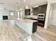 Open concept kitchen with a large kitchen island, stainless appliances, and modern dark wood cabinets at 8813 Moss Glen Dr, Raleigh, NC 27617