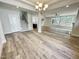 Open living area showcasing hardwood floors, stairway, and modern lighting fixtures, with a seamless flow at 8813 Moss Glen Dr, Raleigh, NC 27617