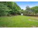 Expansive backyard featuring a large grassy area, trees, fenced perimeter, and a storage shed at 900 Borage Dr, Wake Forest, NC 27587