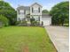 Charming two-story home with light green siding, black shutters, and a well-manicured lawn at 900 Borage Dr, Wake Forest, NC 27587