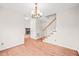 Open-concept living space with hardwood floors, staircase, and glimpse of fireplace adding charm at 900 Borage Dr, Wake Forest, NC 27587