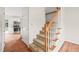 Carpeted stairs with white risers and wooden railing, leading to upper level, adjacent to the kitchen at 900 Borage Dr, Wake Forest, NC 27587