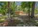 Wide shot of backyard with mature trees and back of brick home at 903 Da Vinci St, Durham, NC 27704