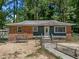 Charming single-story home featuring a brick and siding exterior with a swing, fenced yard and mature trees at 903 Da Vinci St, Durham, NC 27704