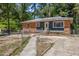 Charming single-story home featuring a brick and siding exterior with a fenced yard and mature trees at 903 Da Vinci St, Durham, NC 27704