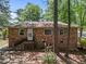 This angle showcases the rear brick exterior of the house, complemented by the verdant surroundings at 903 Da Vinci St, Durham, NC 27704