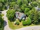 Aerial view of a home nestled among lush trees, showcasing its roofline, surrounding greenery, and neighborhood layout at 100 Michaels Way, Chapel Hill, NC 27516