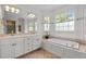 Spacious bathroom boasts a double vanity, soaking tub, and a large window providing natural light at 100 Michaels Way, Chapel Hill, NC 27516
