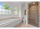 Bathroom featuring a soaking tub, a separate shower with glass door, and a bright window at 100 Michaels Way, Chapel Hill, NC 27516