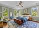 Cozy bedroom with a ceiling fan, complemented by an elegant blue rug and natural light from multiple windows at 100 Michaels Way, Chapel Hill, NC 27516