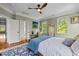 Bright bedroom featuring a ceiling fan, hardwood floors, and generous natural light from large, well-placed windows at 100 Michaels Way, Chapel Hill, NC 27516